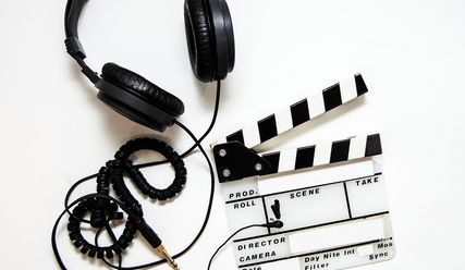 Kabelgebundene Kopfhörer und eine Filmklappe - Copyright: Bokskapet auf Pixabay 