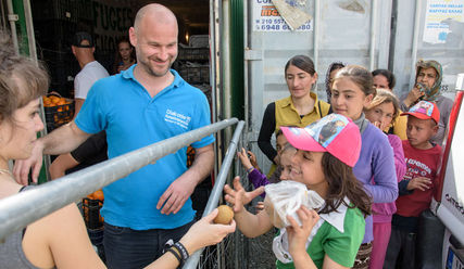 Nothilfe im Flüchtlingslager Idomeni in Griechenland: Markus Koth verteilt Lebensmittel an Geflüchtete - Copyright: Thomas Lohnes/Diakonie Katastrophenhilfe