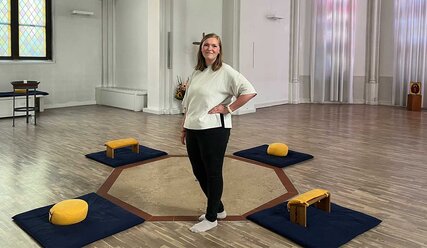 Frau steht in einer Kirche umgeben von Meditationskissen - Copyright: Yvonne Nadler