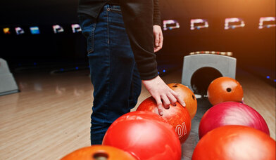 nahaufnahme-der-hand-des-bowlingspielers-die-den-roten-ball-aus-dem-schuessellift-nimmt - Copyright: Bild von ASphotofamily auf Freepik